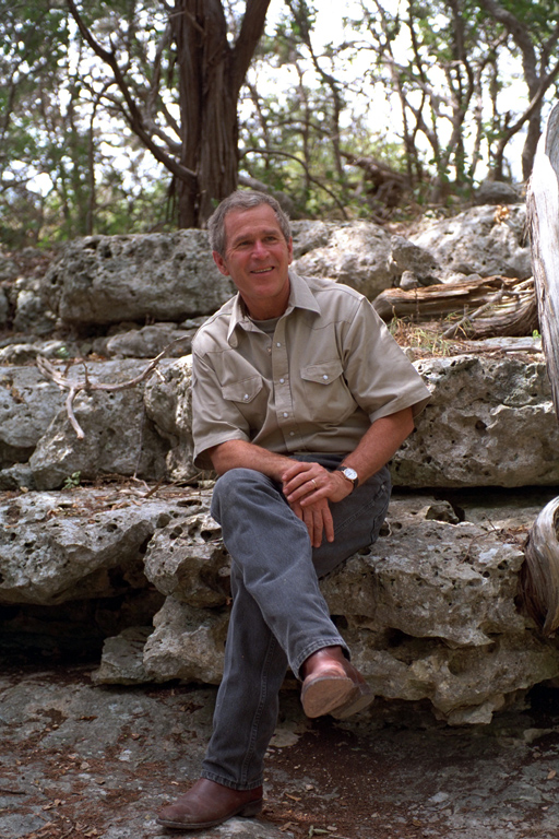 President George W. Bush sits on a rock, August 16, 2001, at Prairie Chapel Ranch in Crawford, Texas. (P6297-29)
