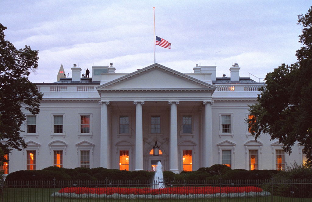 The American flag flies at half-staff over the White House at sunrise, September 14, 2001, as counter assault team (CAT) members are posted on the roof. (P7318-23)