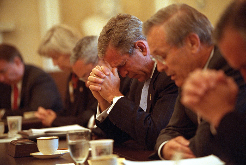 Led in prayer by Secretary of Defense Donald Rumsfeld, right, President George W. Bush joins his Cabinet as they bow their heads, September 14, 2001, before beginning their meeting in the Cabinet Room of the White House. (P7323-09a)