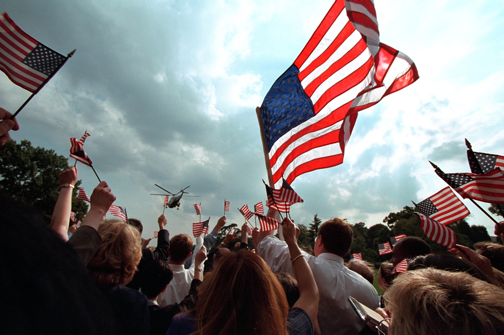Staff members gathered on the South Lawn of the White house wave American flags, September 21, 2001, as President George W. Bush and Mrs. Laura Bush depart for Camp David aboard Marine One. (P7680-23)