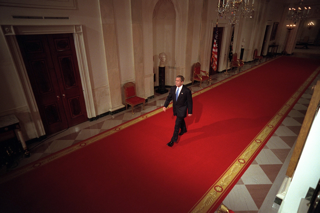 President George W. Bush walks across Cross Hall to the East Room of the White House, October 11, 2001, to give a press conference. (P8468-08)
