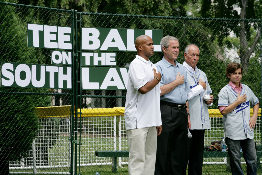 President George W. Bush is joined during the playing of the National Anthem by Roberto Clemente Jr., Angel Macias, and actor Jake T. Austin at Tee Ball on the South Lawn.