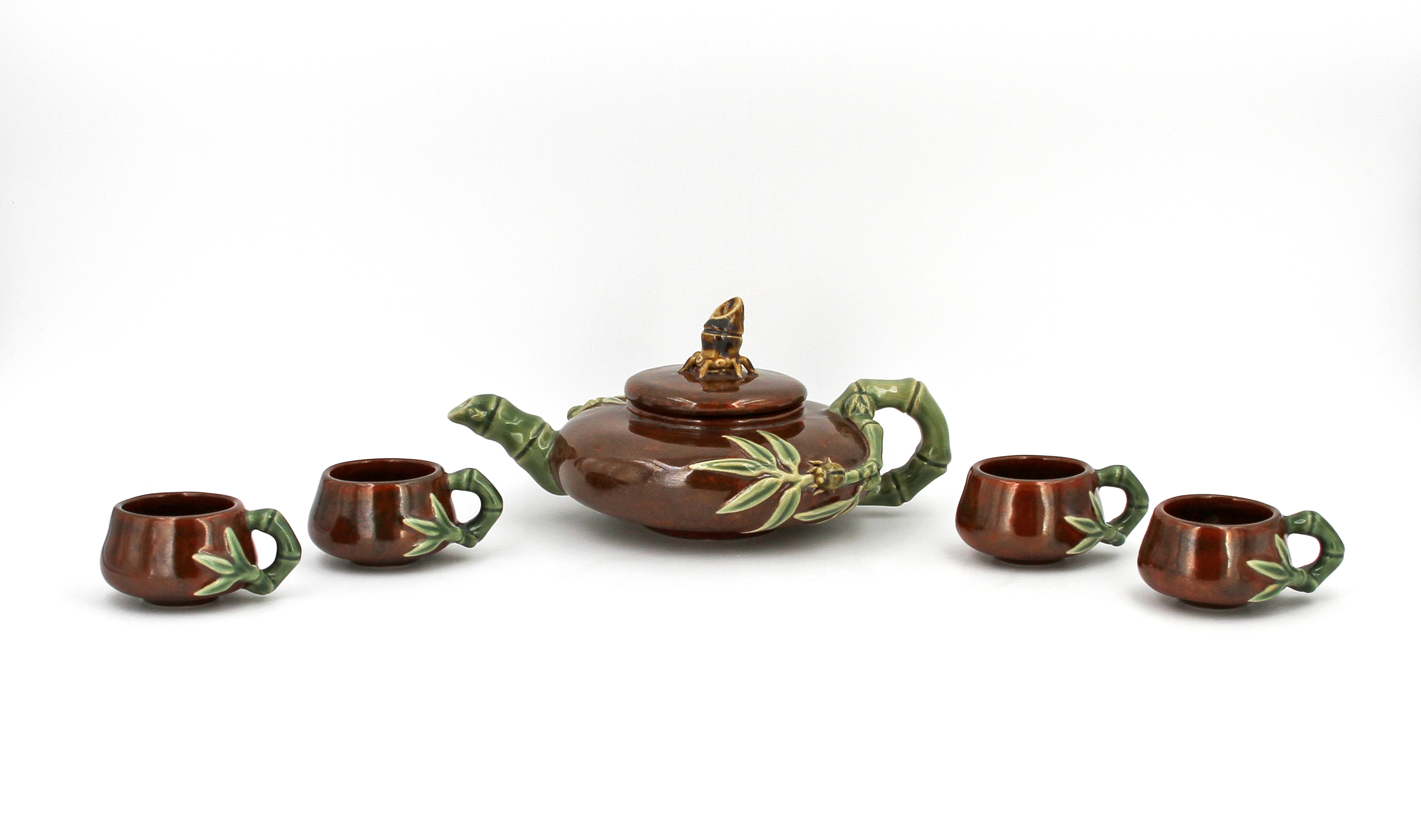 Brown glazed tea set, including a teapot with lid and four cups, all with green bamboo handles and designs. Presented by Donald Tsang Yam-Kuen, Chief Executive of the Hong Kong Special Administrative Region of the People’s Republic of China.