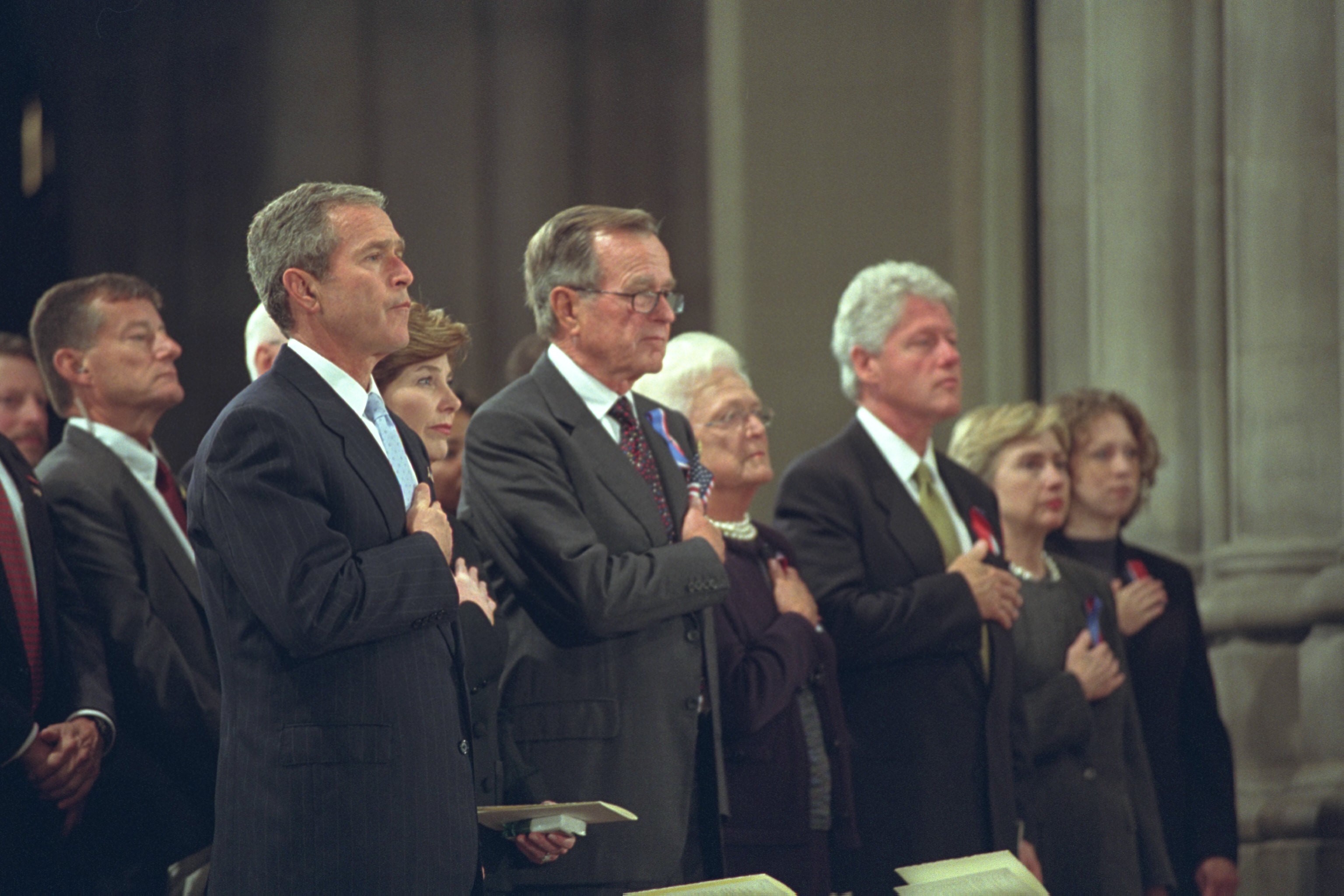President George W. Bush, Mrs. Laura Bush, Former President George H. W. Bush, Mrs. Barbara Bush, Former President Bill Clinton, Sen. Hillary Rodham Clinton, and Chelsea Clinton, stand with hands over hearts for the Pledge of Allegiance during the National Day of Prayer and Remembrance service at the National Cathedral in Washington, DC.