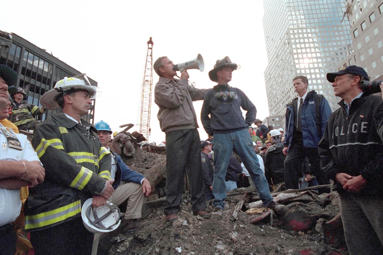 President Bush, standing atop a crumpled fire, speaks to first responders at Ground Zero