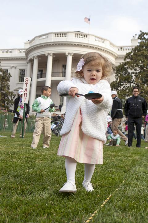 A young child carefully balances her Easter Egg on a spoon, March 24, 2008 on the South Lawn of the White House, during the 2008 White House Easter Egg Roll.