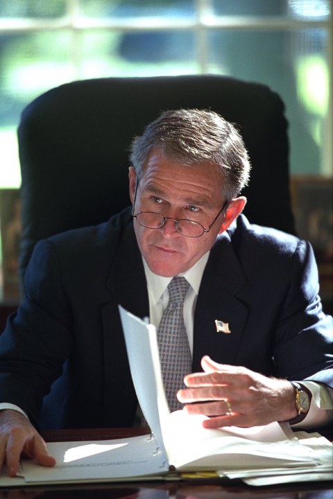 President George W. Bush reads a briefing in the Oval Office of the White House.