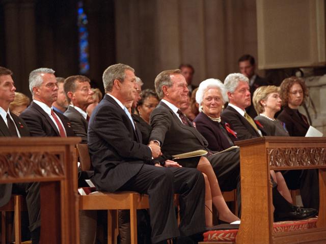 President George W. Bush grasps the hand of his father, former President George H. W. Bush, September 14, 2001, after speaking at the service for America's National Day of Prayer and Remembrance at the National Cathedral in Washington, D.C. (P7338-30)