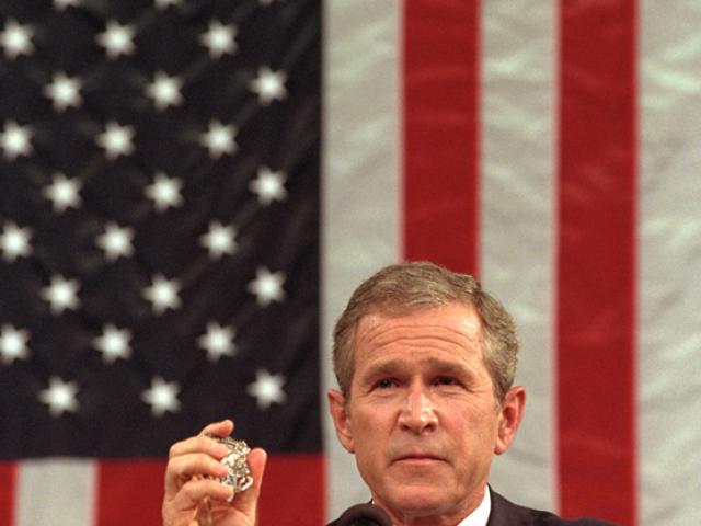 President George W. Bush holds the badge of a Port Authority Police officer killed in the September 11 attacks.