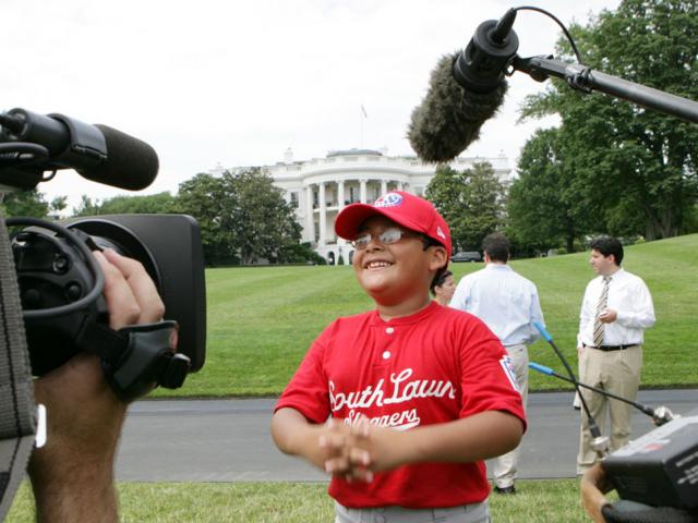 A player with the Cramer Hill Little League Red Sox of Camden, New Jersey, is the center of media attention.