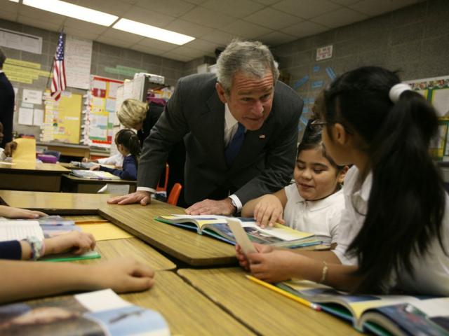 President Bush speaks with students at their desks