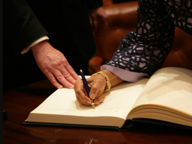 Ellen Johnson Sirleaf signs a book in the White House