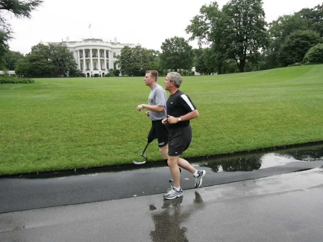 President George W. Bush runs with U.S. Army Staff Sergeant Christian Bagge of Oregon, on the South Lawn, June 27, 2006. President Bush met Sgt. Bagge at Brooke Army Medical Center January 1, 2006, where he promised to run with Sgt. Bagge.