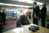 Director of Communications Dan Bartlett points to news footage of the World Trade Center Towers burning, September 11, 2001, as President George W. Bush gathers information about the attack while still at the Emma E. Booker Elementary School in Sarasota, Florida. (P7058-20A)