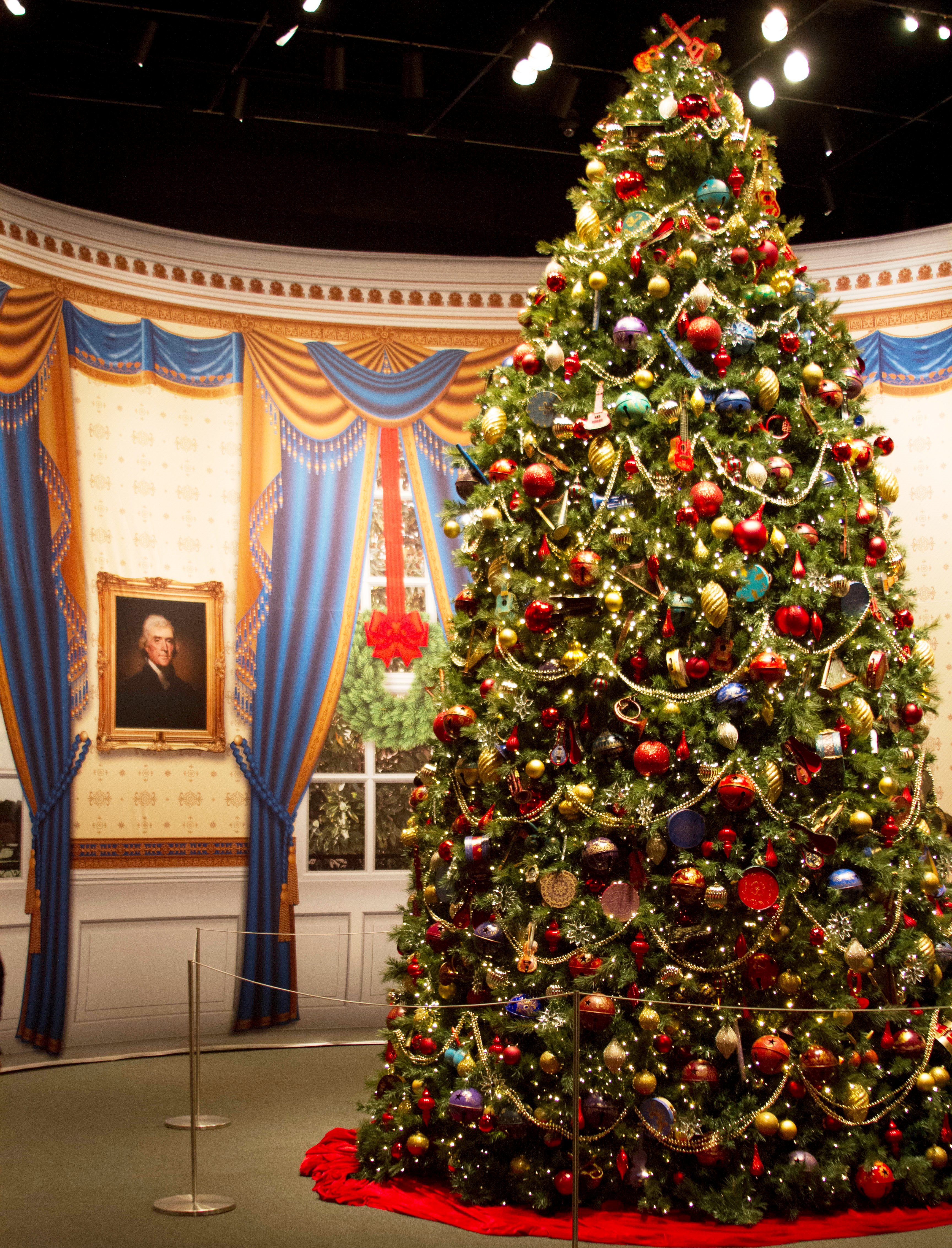 A photo of a replica Blue Room Christmas Tree decorated in the 2004 White House holiday theme 'A Season of Merriment and Melody,' part of the 2016 Holiday exhibit at the George W Bush Library and Museum 