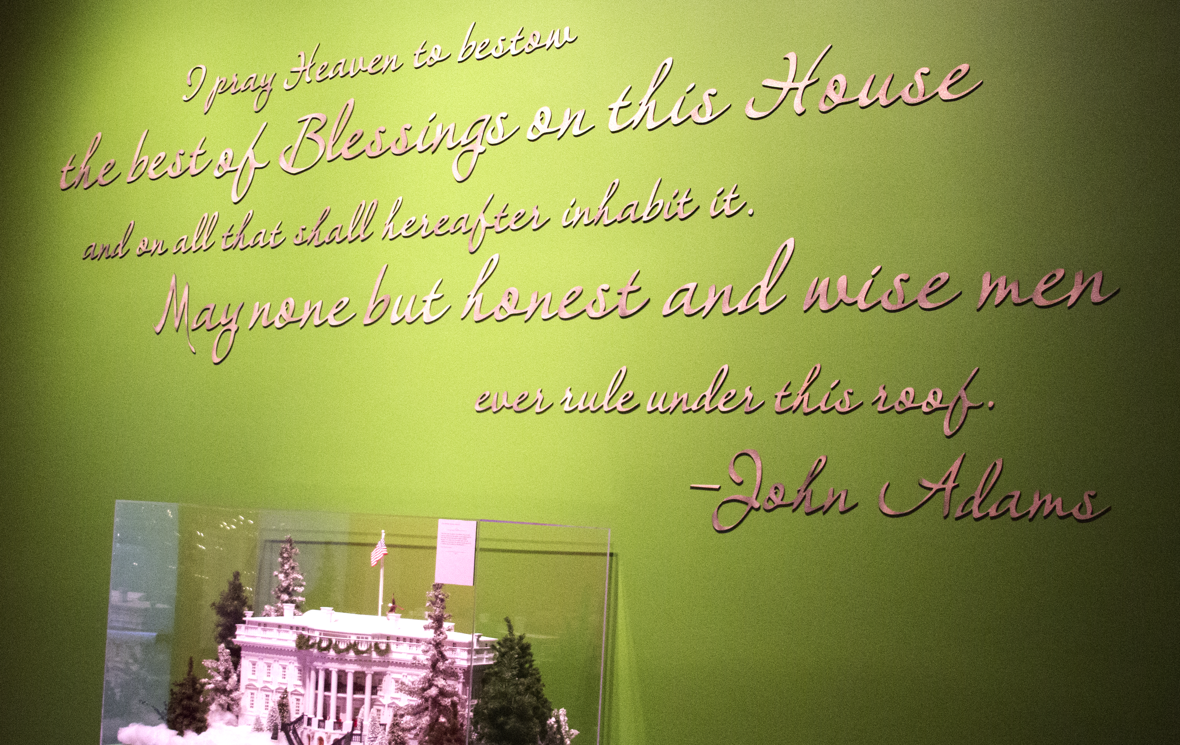 A photo of a quotation from John Adams, 'I pray heaven to best the best of Blessing on the House and on all that shall hereafter inhabit it. May none but honest and wise men ever rule under this roof,' at the gallery entrance to the 2017 Holiday exhibit at the George W. Bush Library and Museum