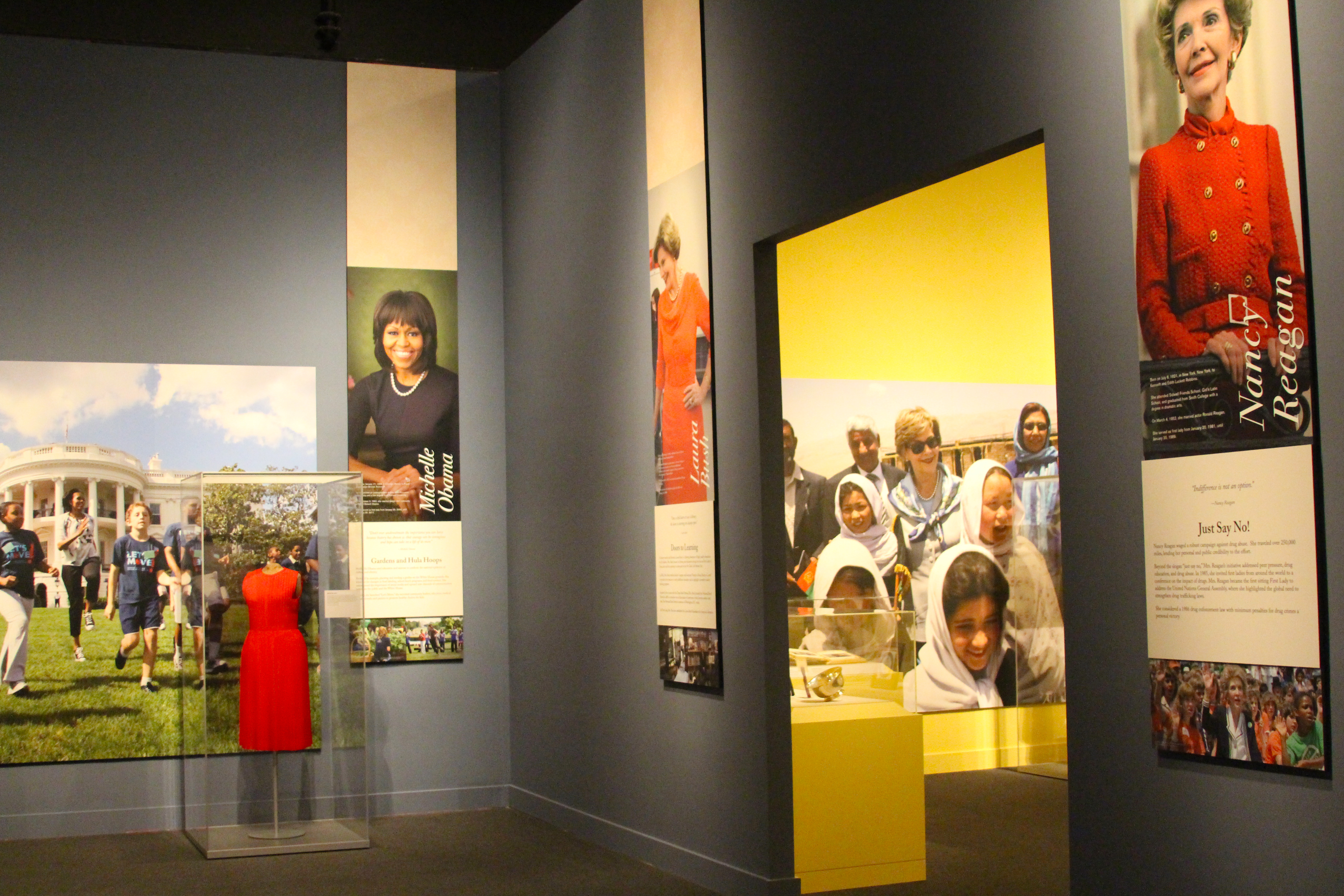 A photo showing two rooms in the 2018 First Ladies exhibit at the George W Bush Library and Museum, featuring pictures of Nancy Reagan, Laura Bush and Michelle Obama