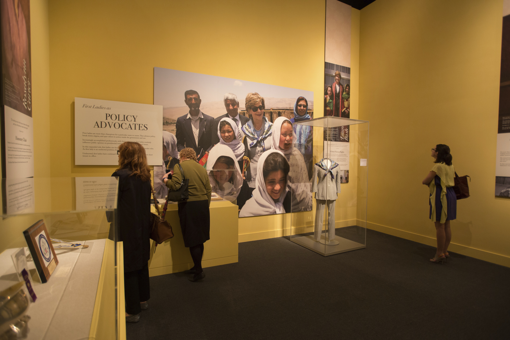 A picture of visitors looking at a display about First Lady Laura Bush's travels, part of the 2018 First Ladies exhibit at the George W Bush Library and Museum