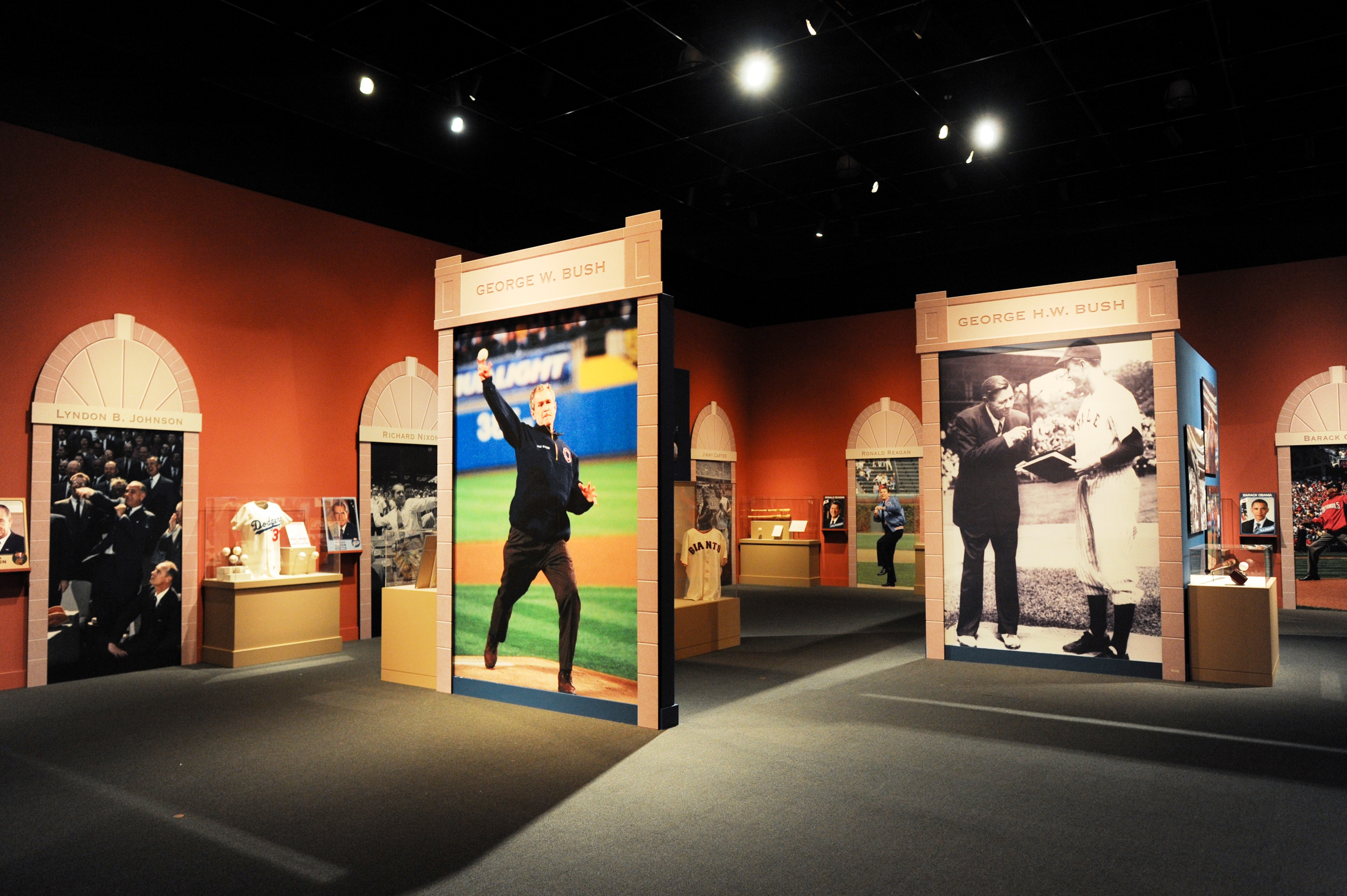 A photo of the 2015 exhibit 'Baseball: America's Presidents, America's Pastime,' at the George W Bush Library and Museum featuring a picture of President George W Bush throwing a first pitch