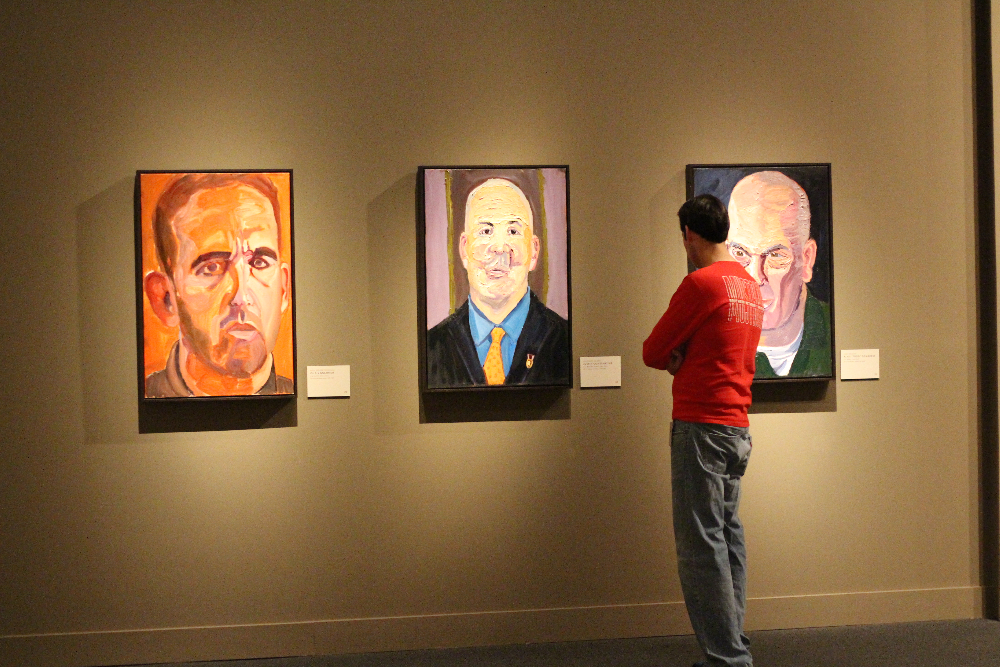 A photo of a visitor looking at portraits by President George W Bush, part of the 2017 exhibit Portraits of Courage, at the George W Bush Library and Museum