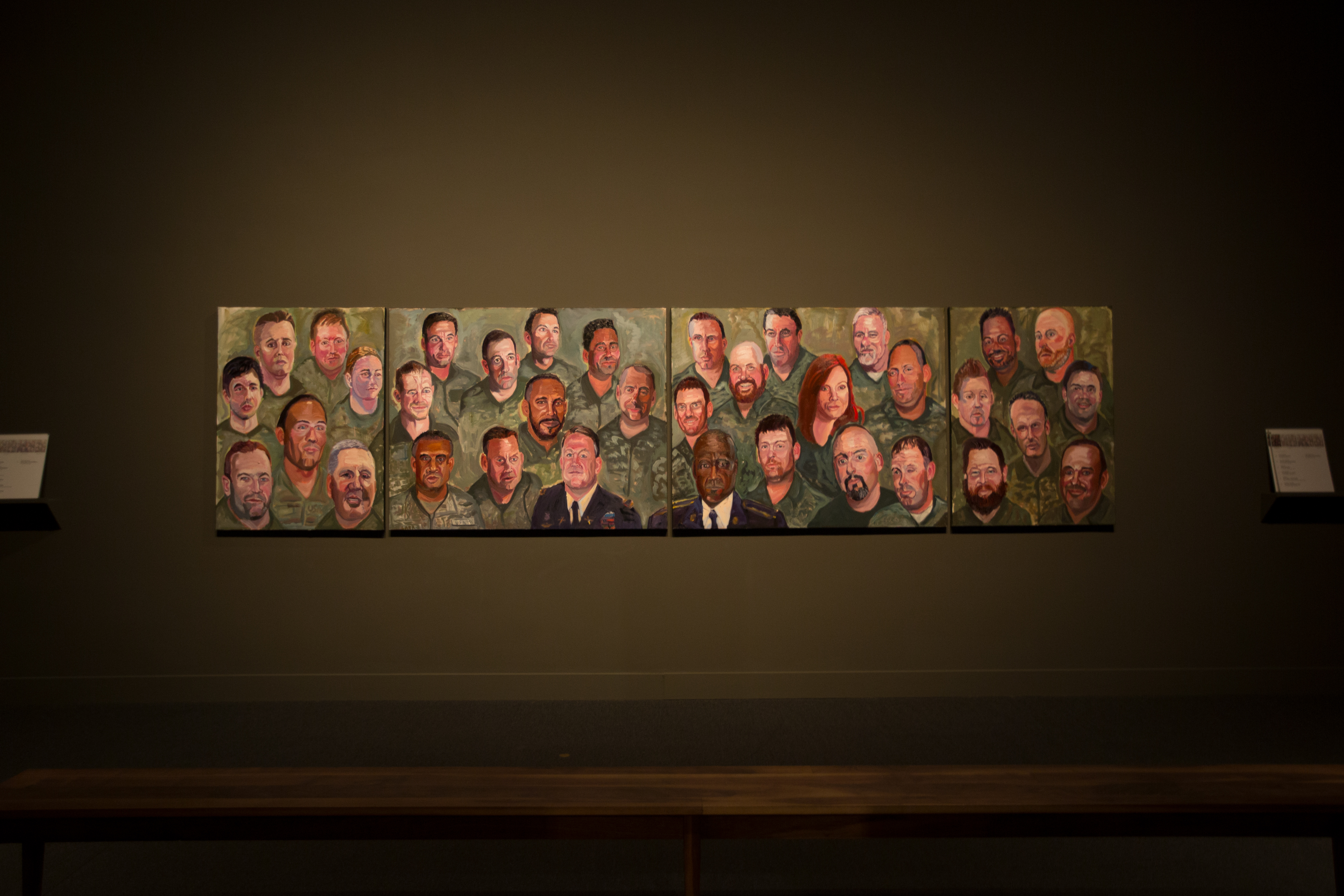 A photo of a wall featuring portraits in a multi-panel mural, part of the 2017 Portraits of Courage exhibit at the George W Bush Library and Museum.