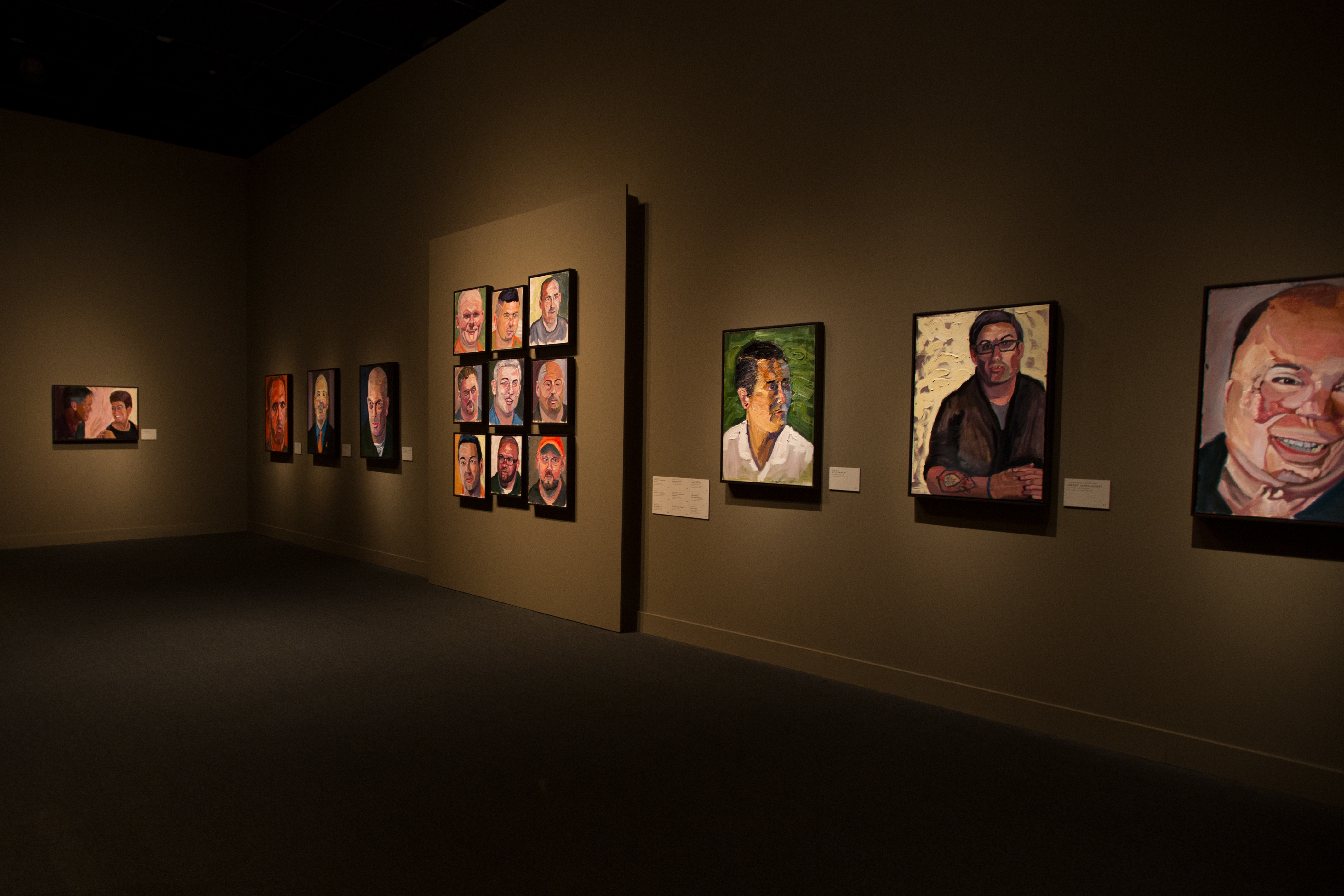 A photo of walls lined with portraits painted by President Bush, from the 2017 Portraits of Courage exhibit at the George W Bush Library and Museum.