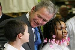 President George W. Bush talks with sixth grade student Mariano Ramos, 11, left, and seventh grader Amber McCarthy, 12, during a visit to the Horace Greeley Elementary School in Chicago on January 7, 2008.