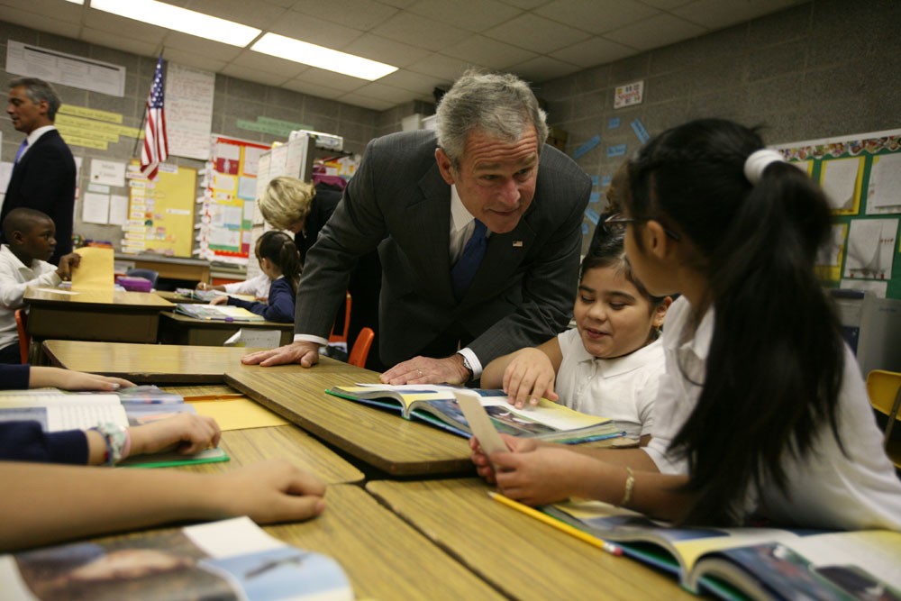 President Bush speaks with students at their desks
