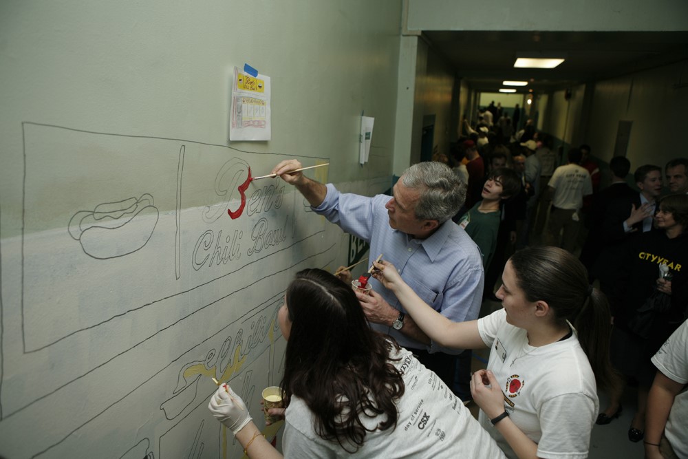 President Bush helps students paint a mural 