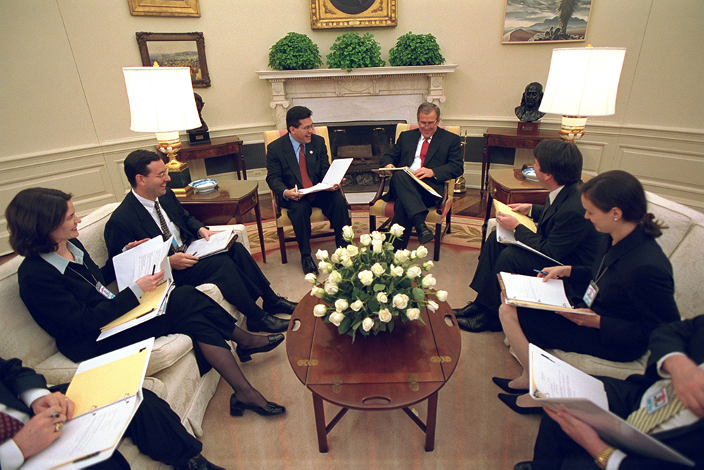President George W. Bush sits with staff in Oval Office 