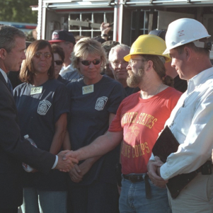 President George W. Bush shakes hands with construction workers rebuilding after Hurricane Katrina.