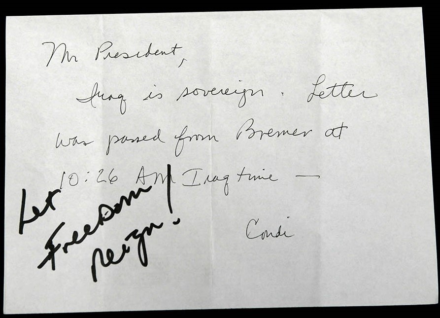 President George W. Bush receives confirmation of Iraqi sovereignty, then wrote, “Let Freedom Reign!” during the opening session of the NATO Summit in Istanbul, Turkey, June 28, 2004.