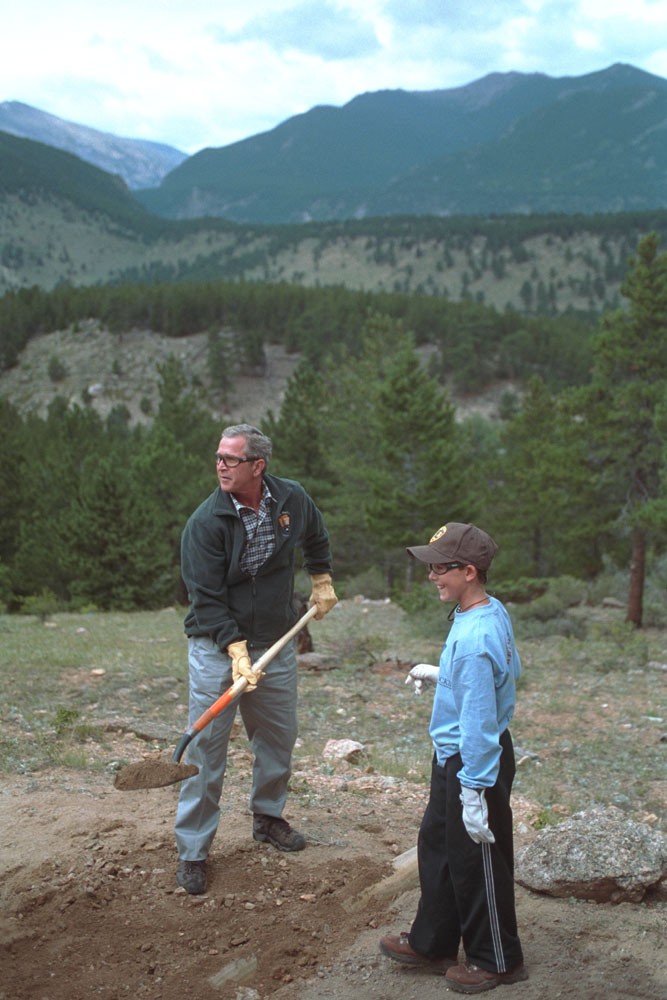 President George W. Bush helps build a trail at Rocky Mountain National Park in Estes, Colorado, August 14, 2001.