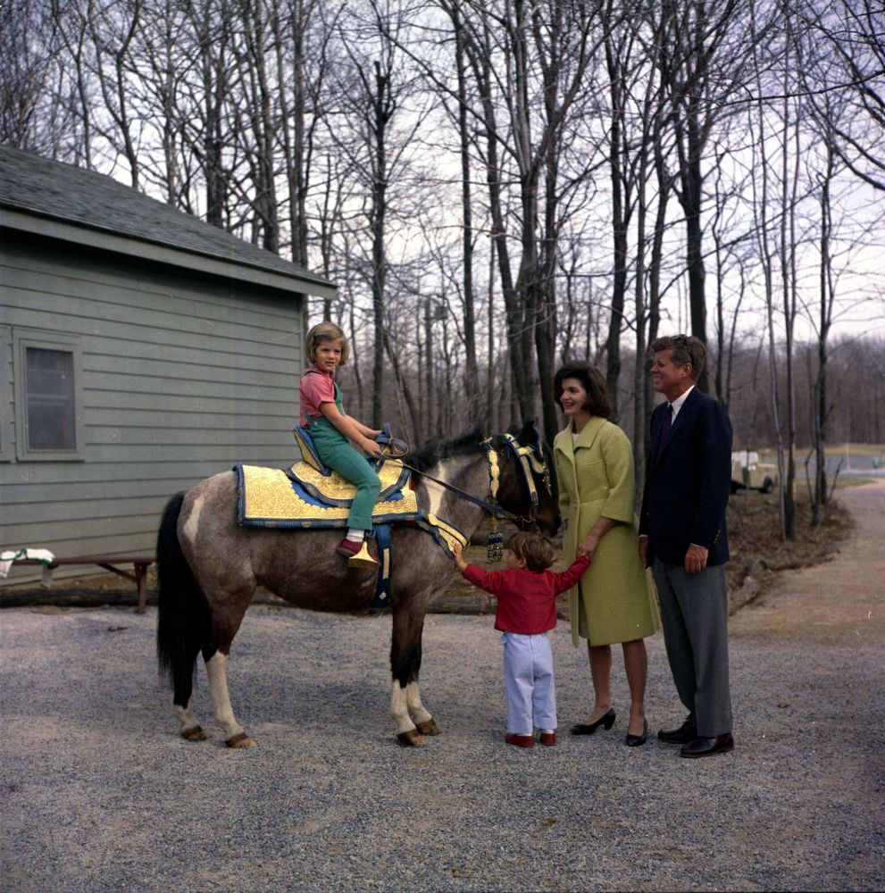 President John F. Kennedy and family watch Caroline Kennedy riding Macaroni at Camp David, Maryland, March 31, 1963. Robert Knudsen, White House Photographs. John F. Kennedy Presidential Library and Museum, Boston. KN-C27672.