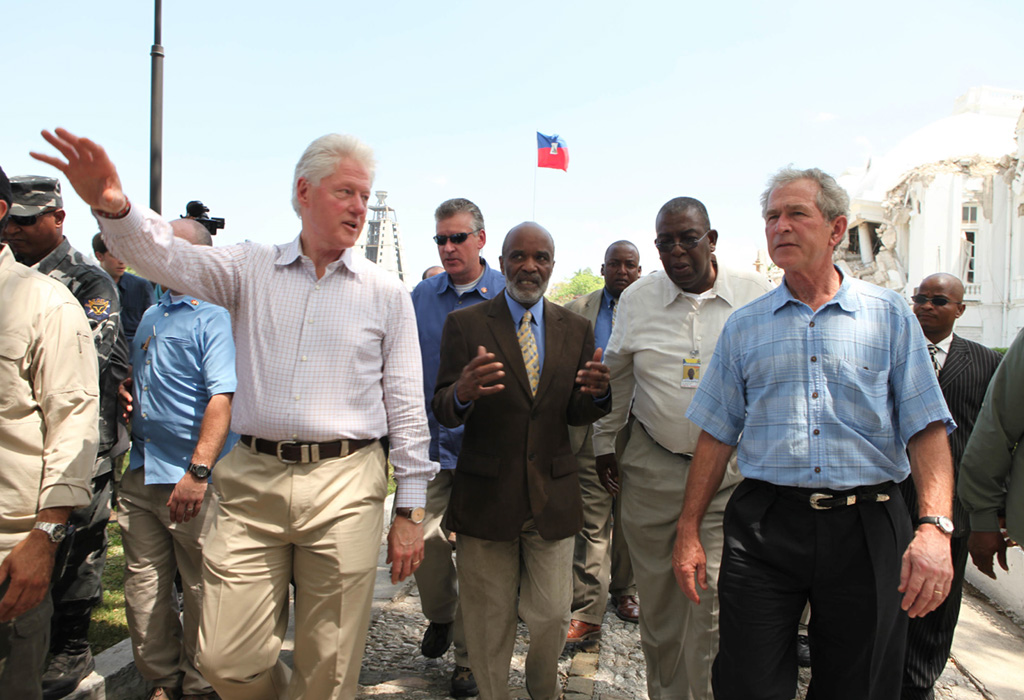 Presidents George W. Bush and Bill Clinton survey damage en route to Palace West Camp during a visit to Haiti on March 22, 2010.