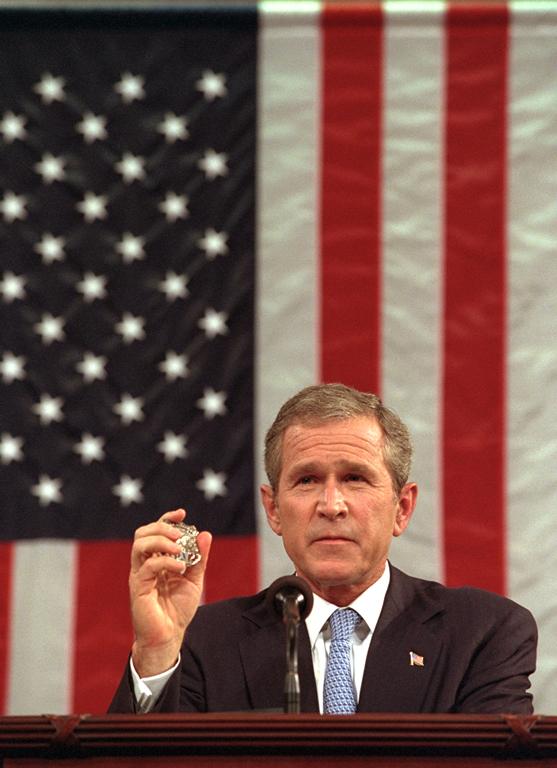 President George W. Bush holds the badge of a Port Authority Police officer killed in the September 11 attacks.