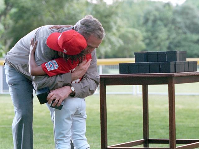 President George W. Bush offers a congratulatory hug as game balls are handed out.