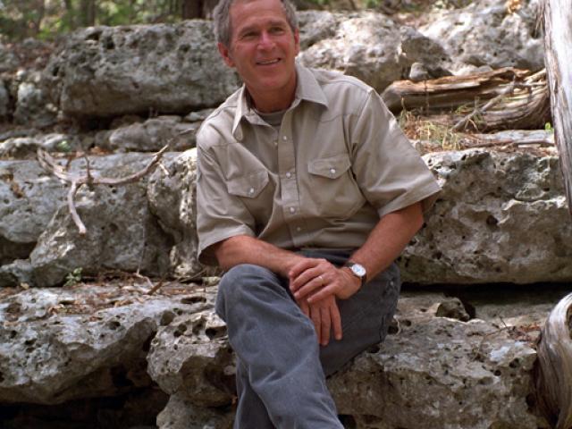 President George W. Bush sits on a rock, August 16, 2001, at Prairie Chapel Ranch in Crawford, Texas. (P6297-29)