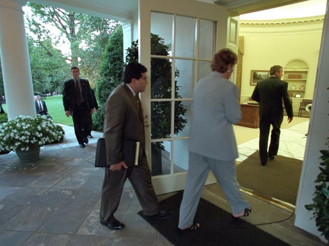 Counselor Karen Hughes and Counsel Alberto Gonzales follow President George W. Bush into the Oval Office, September 11, 2001. (P7110-08)