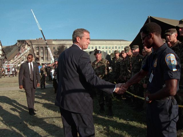 President George W. Bush greets rescue workers, firefighters and military personnel, September 12, 2001, while surveying damage caused by the previous day's terrorist attacks on the Pentagon in Arlington, Virginia. (P7234-21)