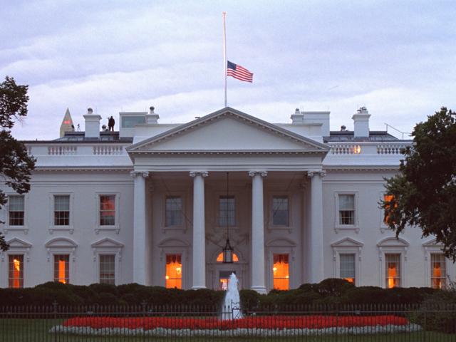 The American flag flies at half-staff over the White House at sunrise, September 14, 2001, as counter assault team (CAT) members are posted on the roof. (P7318-23)