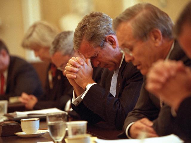 Led in prayer by Secretary of Defense Donald Rumsfeld, right, President George W. Bush joins his Cabinet as they bow their heads, September 14, 2001, before beginning their meeting in the Cabinet Room of the White House. (P7323-09a)