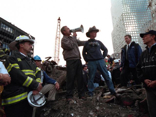 President George W. Bush rallies firefighters and rescue workers, September 14, 2001, during an impromptu speech at the site of the collapsed World Trade Center towers. (P7365-23a)