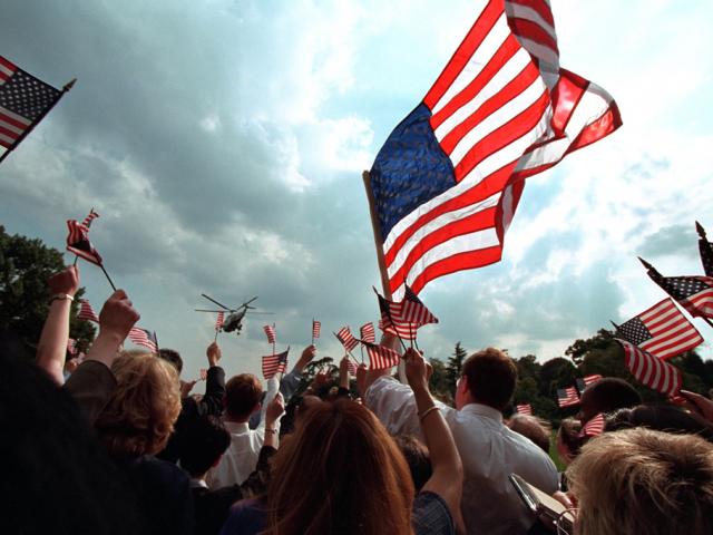 Staff members gathered on the South Lawn of the White house wave American flags, September 21, 2001, as President George W. Bush and Mrs. Laura Bush depart for Camp David aboard Marine One. (P7680-23)