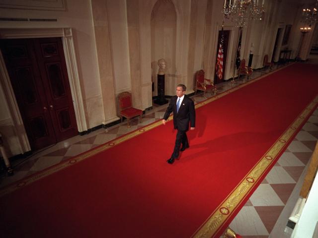President George W. Bush walks across Cross Hall to the East Room of the White House, October 11, 2001, to give a press conference. (P8468-08)