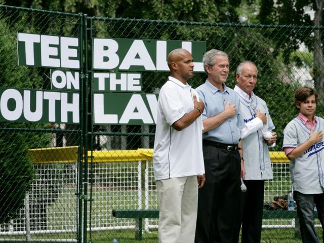 President George W. Bush is joined during the playing of the National Anthem by Roberto Clemente Jr., Angel Macias, and actor Jake T. Austin at Tee Ball on the South Lawn.