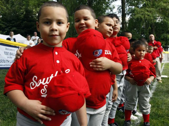 Players hold their hats over their hearts during the singing of the National Anthem.