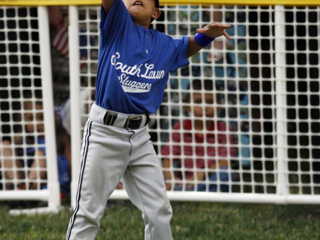 The first base player catches a ball in his glove.