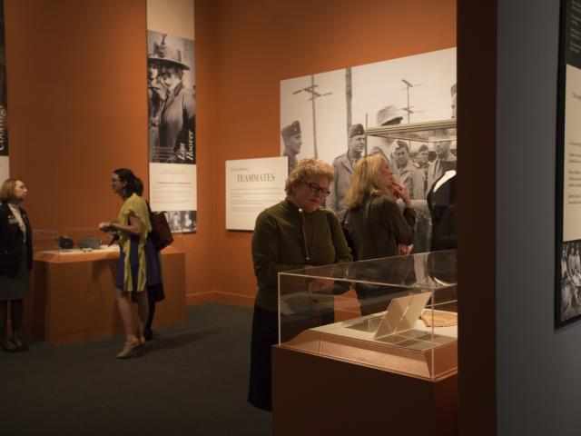 A picture of visitors looking inside display cases from the special exhibit "First Ladies: Style of Influence."
