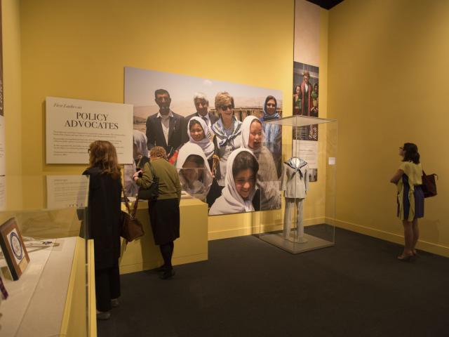 A picture of visitors looking at a display about First Lady Laura Bush's travels, part of the 2018 First Ladies exhibit at the George W Bush Library and Museum